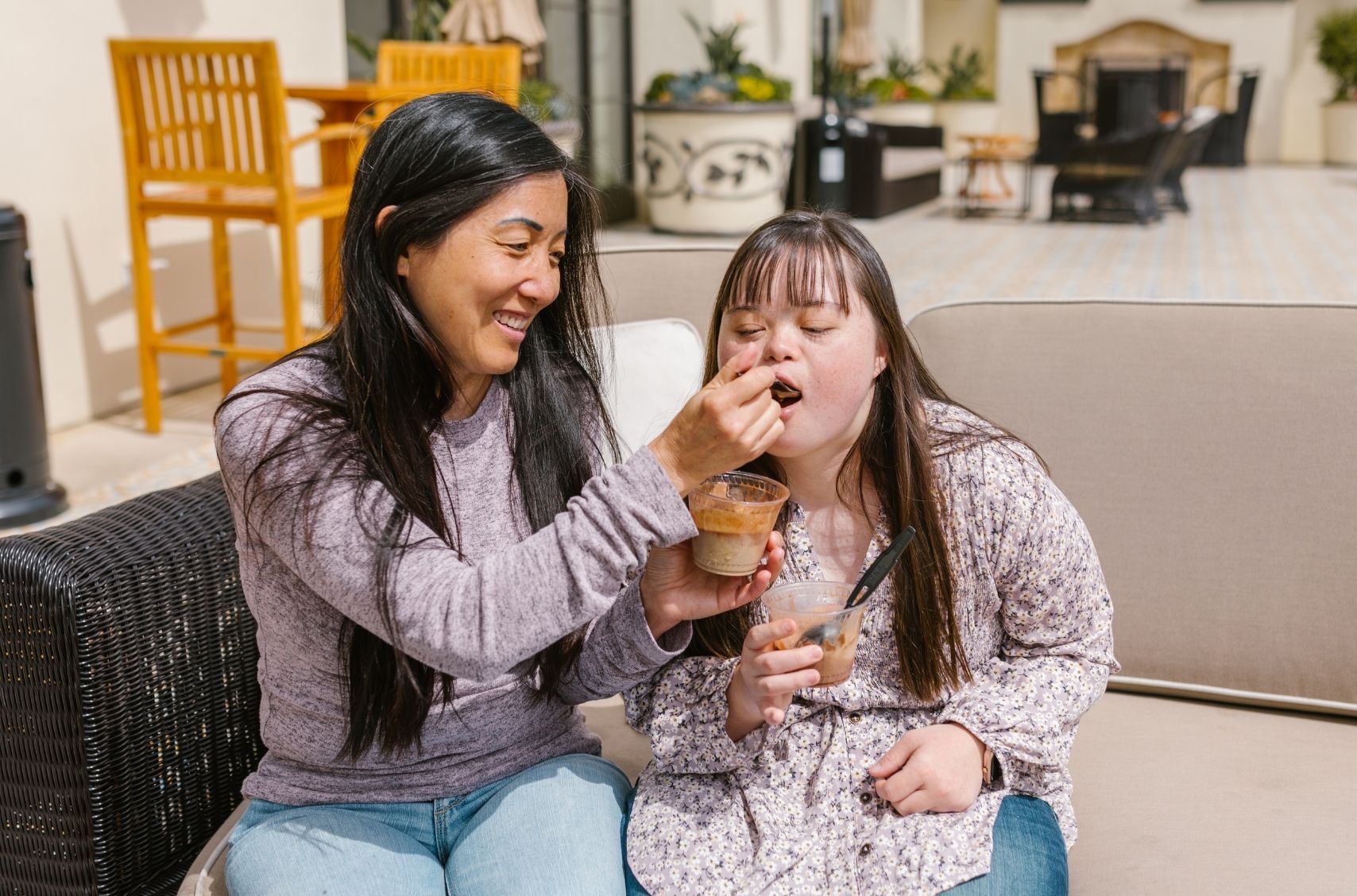 support worker helping to eat food to autistic child